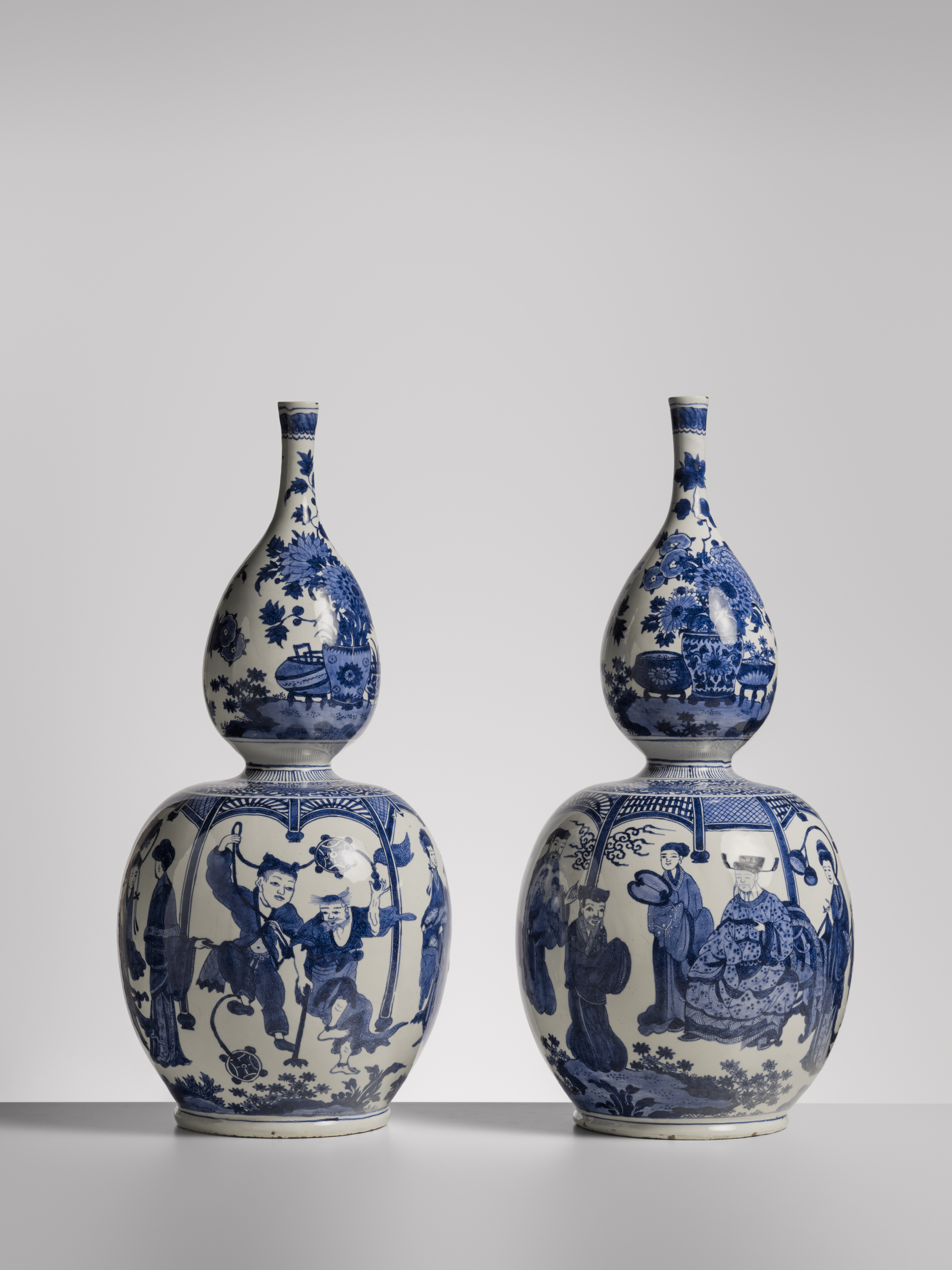 Twee Delfts blauwe vazen met een smalle hals naast elkaar afgebeeld