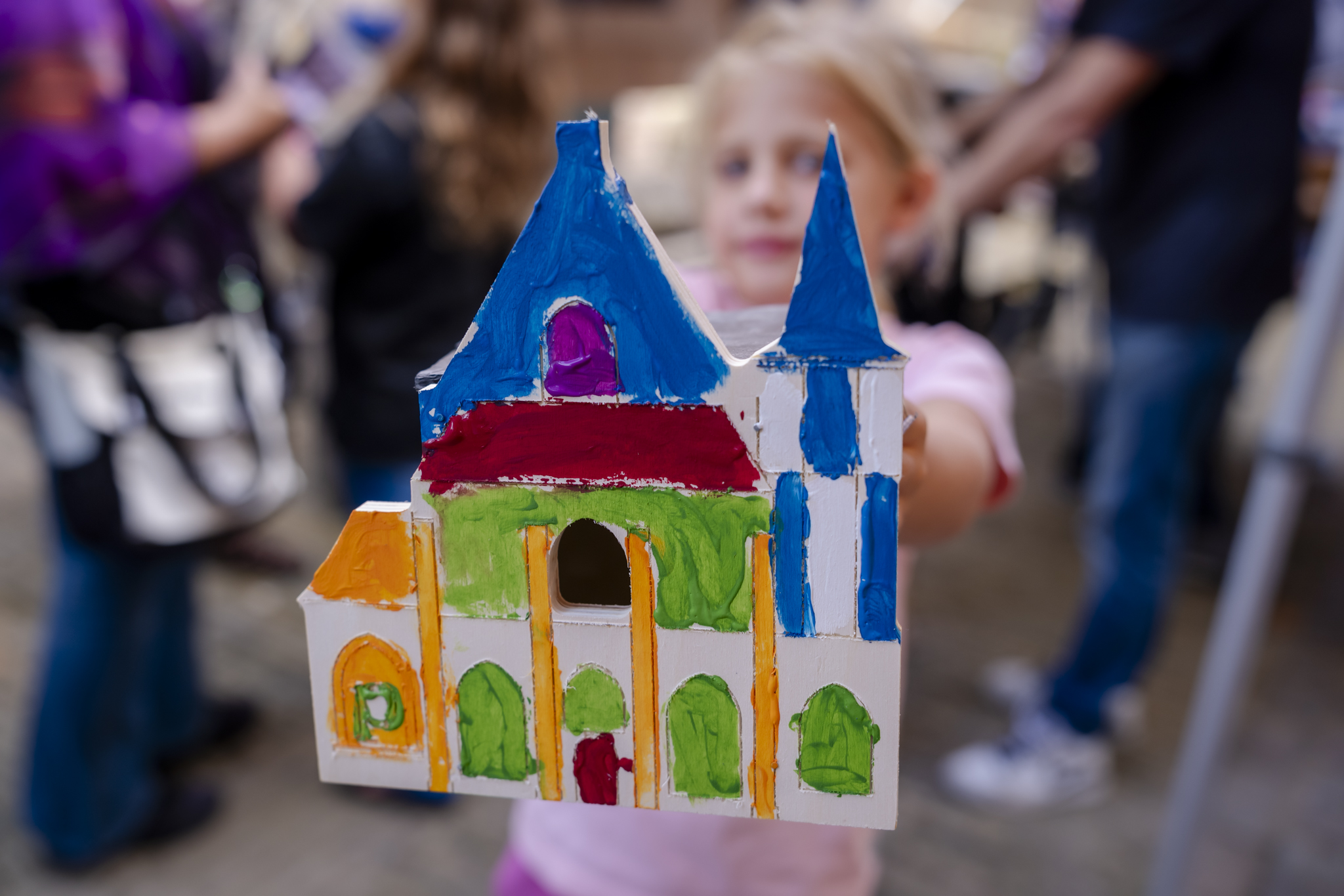 meisje toont zelf beschilderd prinsenhof-vogelhuisje